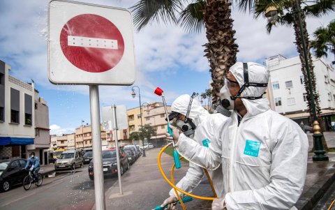 Un trabajador del ministerio de salud marroquí desinfecta un letrero 