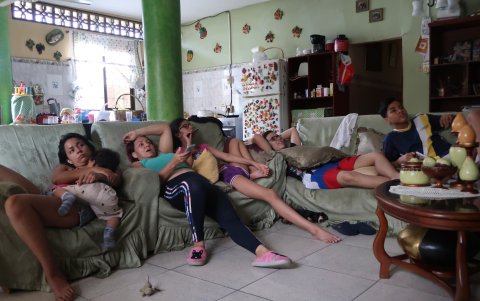 Los miembros de una familias, en Sauces 8,  ven televisión juntos en la sala.