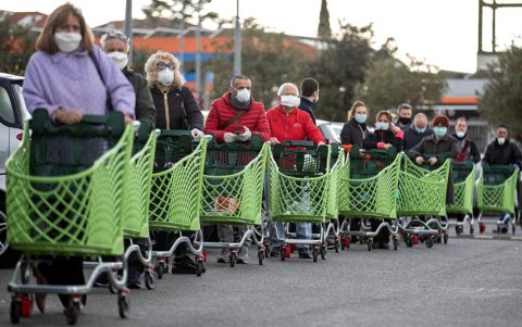 Una escena común en la Italia del coronavirus: personas con mascarilas y extensas filas en los supermercados.