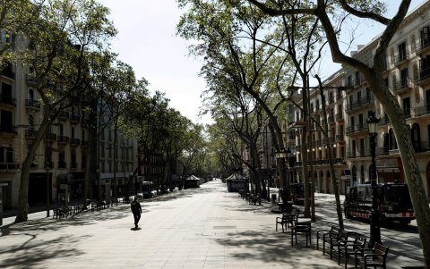 BARCELONA. Un agente de la Guardia Urbana patrulla por las Ramblas, que permanece practicamente vacía, al mediodia de este domingo.