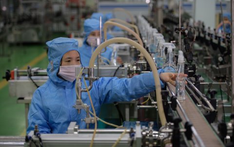 El 19 de marzo, un trabajador revisa botellas de nuevos productos desinfectantes en una línea de producción en la fábrica de jabón Ryongaksan en Pionyang