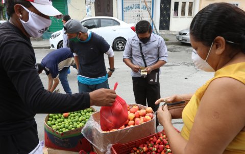 Vendedores informales de frutas y vegetales en las veredas.