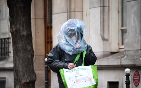 PARÍS, FRANCIA: Un hombre se protege la cara con una bolsa de plástico mientras camina por la calle el 21 de marzo, cuando entra en vigencia un bloqueo preventivo.