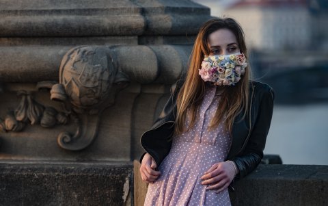 REPÚBLICA CHECA: Una mujer con una máscara llena de flores se encuentra en el Puente de Carlos en Praga, donde la mayoría de las actividades se ralentizaron.