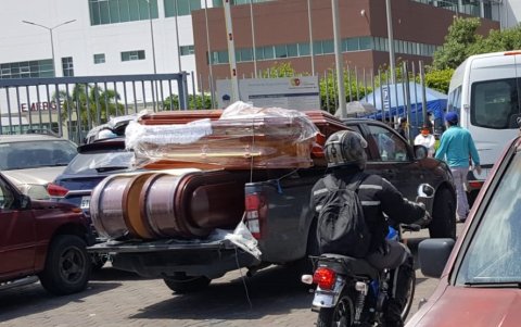 Camionetas llegan cargadas de ataúdes a los exteriores del hospital del Guasmo, en la fase crítica de la pandemia en 2020.
