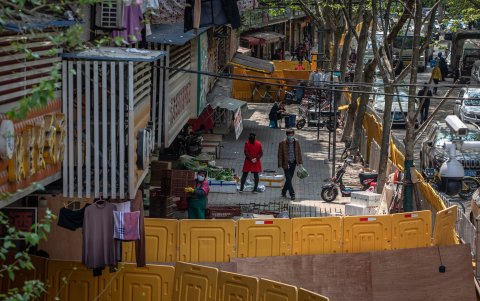 WUHAN. Una pequeña tienda reinició la venta de productos entre los vecinos de uno de los barrios populares de esta ciudad.Aún atiende separados por una barrera.