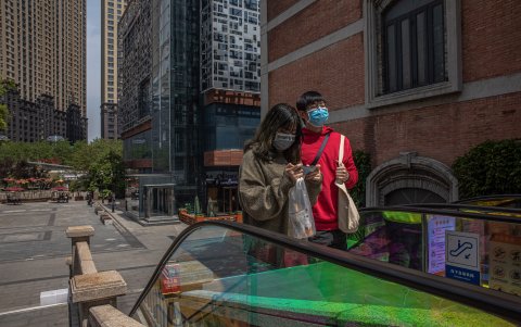 WUHAN. Una pareja camina por una de las calles del epicentro económico de esta ciudad. Hasta este lunes, aún evidenciaba un ausencia de transeúntes.