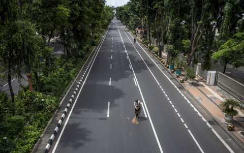 JAVA ORIENTAL, INDONESIA: Un trabajador barre un acceso cerrado como medida preventiva contra el coronavirus en Surabaya.