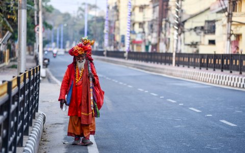 GUWAHATI, INDIA: Un sadhu (hombre santo hindú) camina en una carretera desierta durante un bloqueo nacional impuesto por el gobierno.