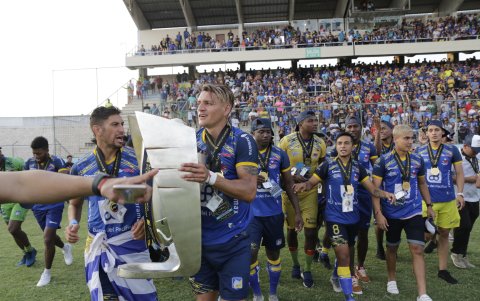 Carlos Garcés (capitán) se encarga de llevar al trofeo de rey al campo.