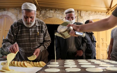 HEBRÓN. Vendedores palestinos preparan dulces antes del mes de ayuno del Ramadán, en esta ciudad ocupada de Cisjordania.