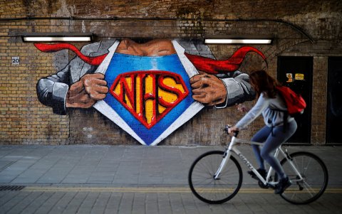 Londres. Un ciclista pasea frente al mural pintado en estos días dedicado al Servicio Nacional de Salud (NHS), por el trabajo durante la emergencia sanitaria.