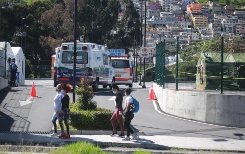 Un grupo de personas, protegidas con mascarillas, pasa frente al Hospital del IESS del Sur de Quito, este fin de semana.
