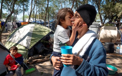 TAMAULIPAS. Jesús Chávez, lleva a su hija Carmen en brazos. Ambos son salvadoreños y viven e carpas en el campamento levantado en un complejo rural en esta provincia mexicana.