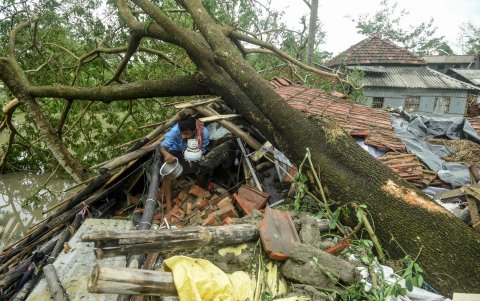MIDNAPORE. Un hombre recupera las partes de su casa dañada por el ciclón que tumbó árboles y aplastó casas. Hay millones de movilizados en medio del riesgo de contagios con el coronavirus.