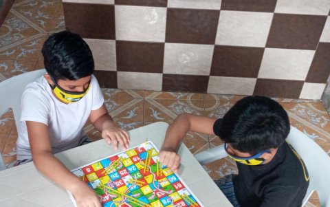 Niños juegan utilizando mascarillas, uno de ellos presentó posibles síntomas leves de COVID-19.