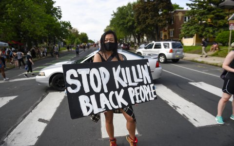 MINNEAPOLIS. Amy Gee, de Minneapolis, sostiene un cartel cerca de la escena del arresto de George Floyd, quien luego murió bajo custodia policial.