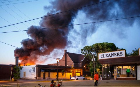 MINÉAPOLIS. Las llamas de un recinto policial y de un local comecial se extiende en el cielo. Miles protestan por la muerte de un afroamericano en esta ciudad.