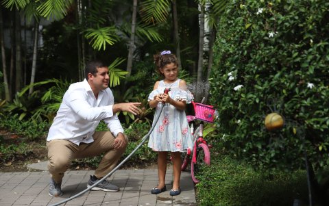 Jardinería. Claudia Huamán riega las plantas junto a su padre, Fernando.