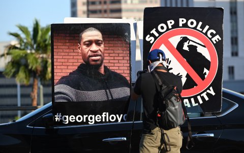 LOS ANGELES. Un hombre toma fotos de carteles durante las protestas en esta ciudad. Unos 10.000 manifestantes se manifestaron por la muerte bajo custodia de George Floyd en Minneapolis.