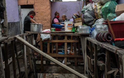 Con mascarillas rojas las mujeres llegan cargando en brazos a sus hijos. Algunas sobre zapatos con tacos altos.