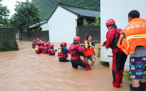YANGSHUO. Rescatistas socorren a una familia en un barrio rural de esta ciudad turística china, que se ha visto afectada por las lluvias.