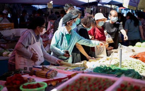 PEKÍN. Varias personas se aprovisionan de frutas en Xinfandi, el mayor de los mercados de la capital china.