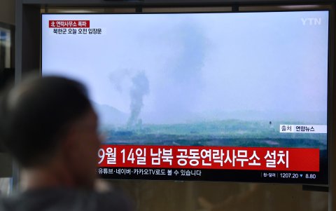 SEÚL. En una estación de ferrocarril, gente mira una pantalla de televisión que muestra la explosión que hizo volar por los aire la oficina de enlace intercoreana.