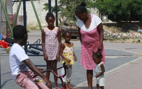 Una familia afroecuatoriana en el sector La Trinitaria situada en el sur de Guayaquil, conversa en las afueras de su casa.