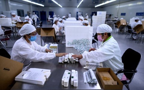 SHENYANG. Trabajadores empaquetan vacunas contra la rabia en un laboratorio de la compañía Yisheng Biopharma, donde se investigan una vacuna para el coronavirus.