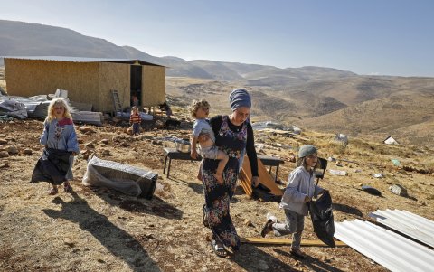 MAOZ ESTER. Una mujer del grupo de colonos israelíes camina con varios niños por el entorno de un puesto avanzada, del lado del asentamiento israelí de Kokhav HaShahar en la Cisjordania ocupada.