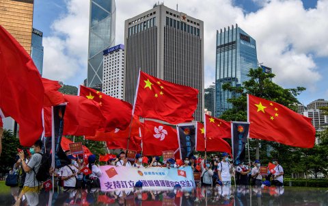 HONG KONG. Partidarios de China exhiben banderas chinas y de Hong Kong durante una manifestación cerca de la sede del gobierno de la isla en apoyo a la promulgación de la nueva ley.