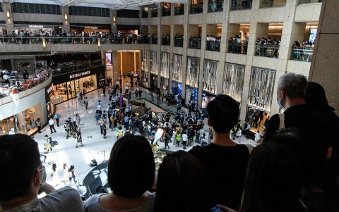 HONG KONG. La gente observa después de que la policía ingresó a un centro comercial para dispersar a las personas que asistieron a un mitin a la hora del almuerzo.