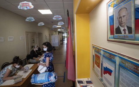 MOSCÚ. Una mujer vota en un recinto electoral donde un retrato de Putin sirve de testigo.