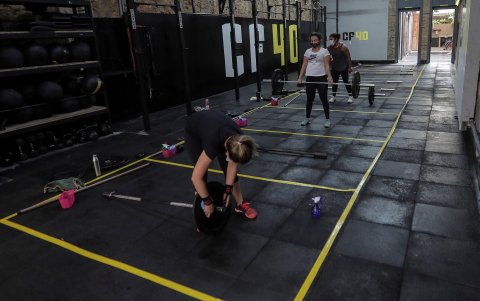 RIO DE JANEIRO. Tres mujeres practican Crossfit en una academia con espacios marcados en el suelo, tras la reapertura de bares, restaurantes y academias de gimnasia.