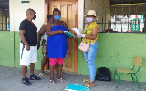 Padres de familia se acercan a recibir las fichas pedagógicas para sus hijos en la escuela 26 de Agosto, del cantón San Lorenzo.
