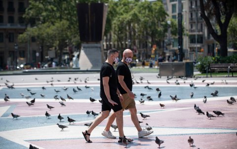 BARCELONA. Dos hombres con máscaras faciales caminan por la plaza de Cataluña. Se observó una ciudad vacía, en especial en las calles céntricas.