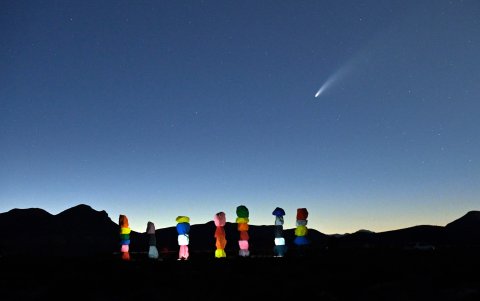 NEVADA (EE. UU.). El cometa atraviesa la noche, coronando la instalación 'Seven Magic Mountains' del artista Ugo Rondinone.