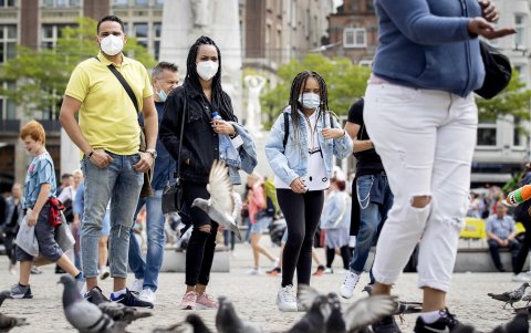 AMSTERDAM. Turistas y excursionistas recorren la Plaza Dam. El municipio de local está tomando medidas adicionales contra las multitudes y espera evitar una mayor propagación de la coronavirus.