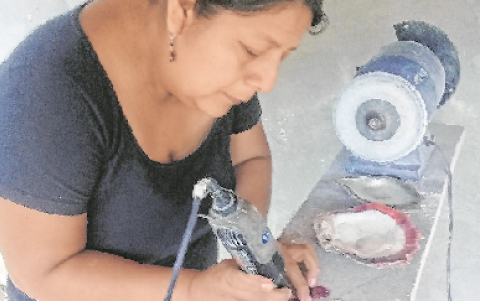 Taller. Alicia Asunción, en su taller ubicado en su casa, da los acabados con un esmeril a uno de sus trabajos de bisutería.