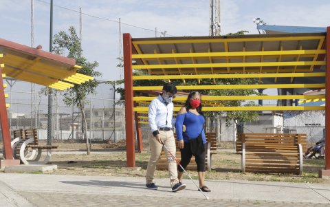 Josué Mieles, de 19 años de edad, pasea junto a su madre, Nancy Mite. Al caminar le gusta percibir el aroma de la comida.