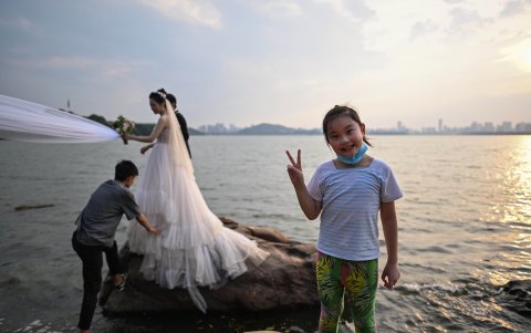 WUHAN. Una niña sonríe mientras al fondo una pareja posa para el álbum familiar antes del matrimonio. Son otros tiempos, no hay dudas.