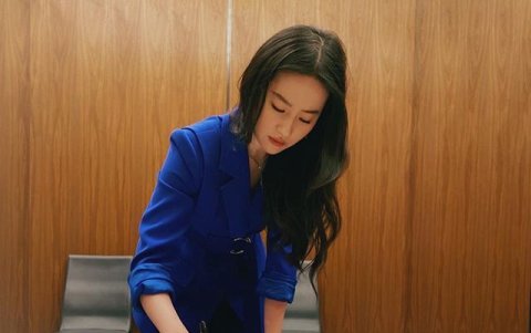 Liu Yifei mientras pone su firma en un poster de Mulan