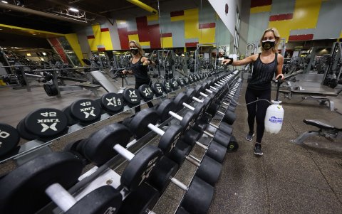 NEW YORK. Una instructora prepara el saón de Gold's Gym en la Gran Manzana. Esparce desinfectante y alcohol por todos lados. Es una manera de ayudar a controlar los contagios.