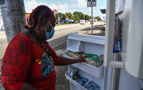 MIAMI. Avis Alexander, una madre de tres hijos, toma comida gratis de un refrigerador comunitario.