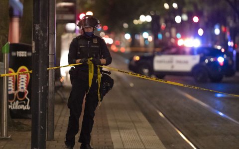 PORTLAND. Un policía resguarda el perímetro del área donde un estadounidese recibió un tiro mortal en el pecho la noche del sábado.