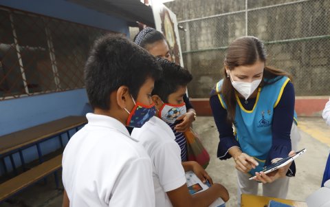 Viviana Salgado, presidenta de la Fundación Madre Solidaria, muestra a los niños el funcionamiento de la tableta.