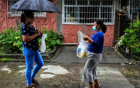 Lorraine Ann Imperio (izquierda) se reúne con Reniel Bariso para intercambiar sus productos en la ciudad de Las Pinas, suburbana de Manila.