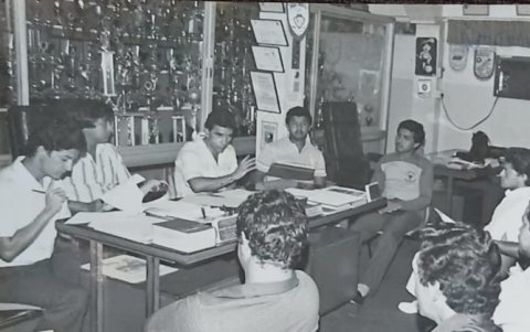 La antigua foto de una reunión en la Dirección de Deportes muestra las vitrinas con decenas de copas y trofeos deportivos