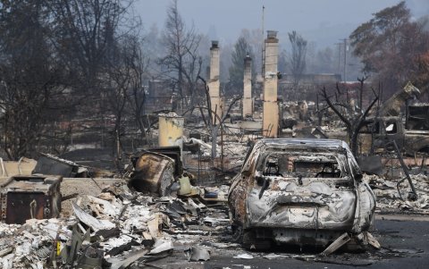 Un carro quemado se ve entre los escombros de las casas destruidas por el incendio de Almeda en Talent, Oregon.